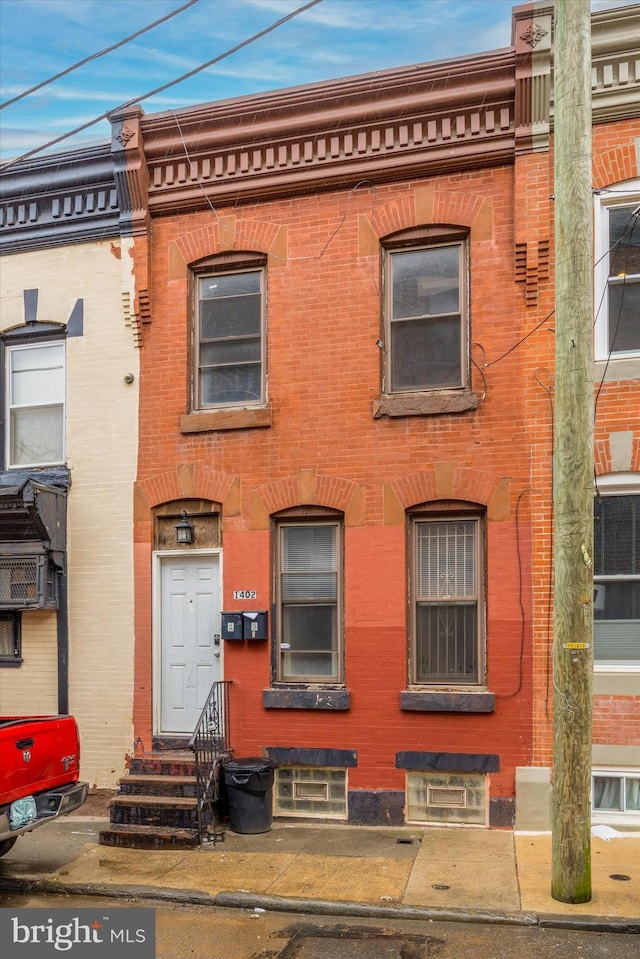 townhome / multi-family property with entry steps and brick siding