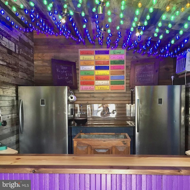 kitchen with wooden walls and freestanding refrigerator