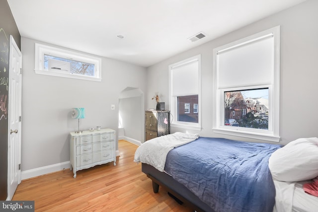 bedroom featuring visible vents, baseboards, and light wood finished floors