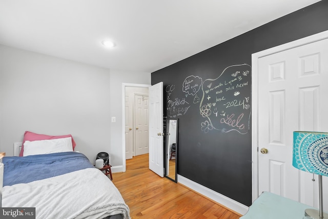 bedroom with light wood finished floors and baseboards