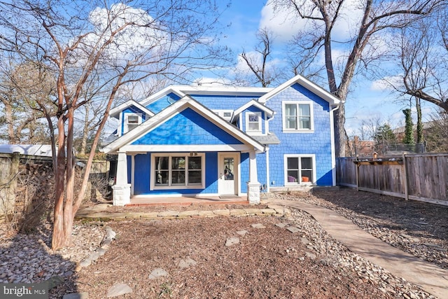 view of front of house featuring fence and covered porch