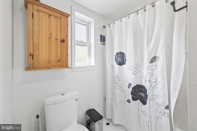 bathroom featuring shower / tub combo and toilet