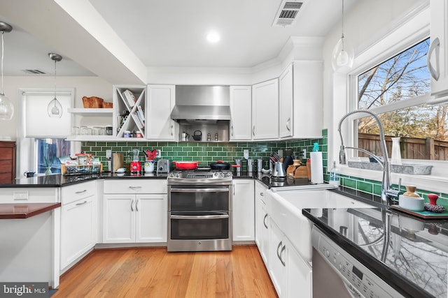 kitchen featuring double oven range, visible vents, dishwasher, wall chimney exhaust hood, and backsplash