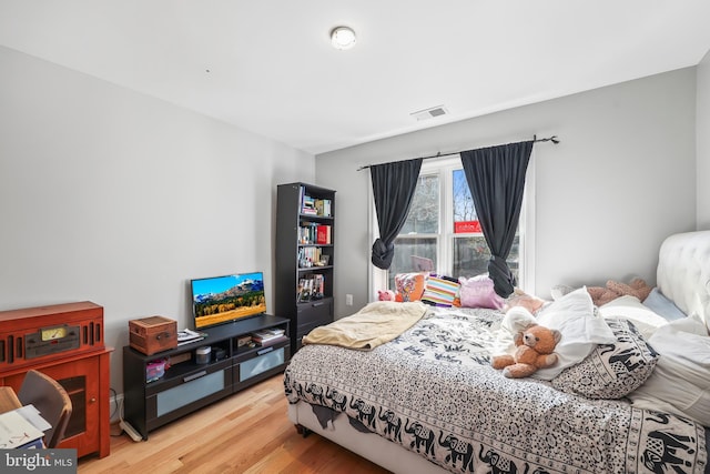 bedroom with wood finished floors and visible vents