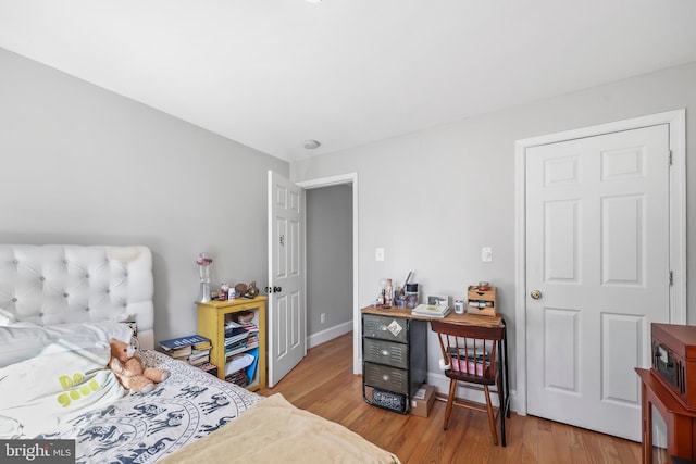 bedroom with baseboards and wood finished floors