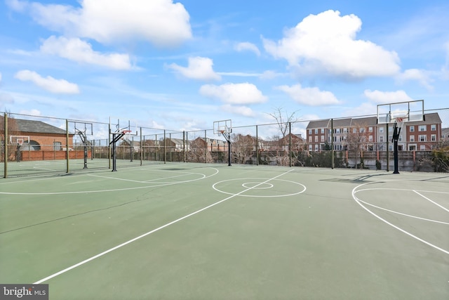 view of sport court featuring a residential view, community basketball court, and fence