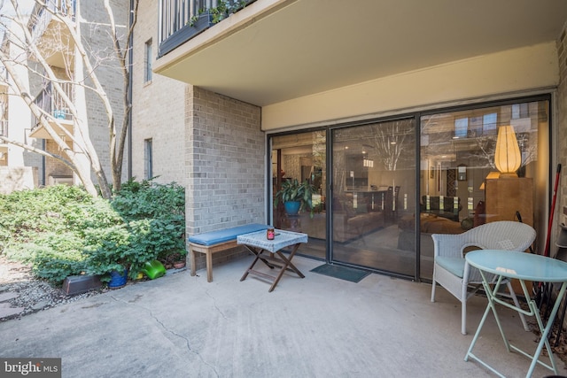 property entrance with a patio and brick siding