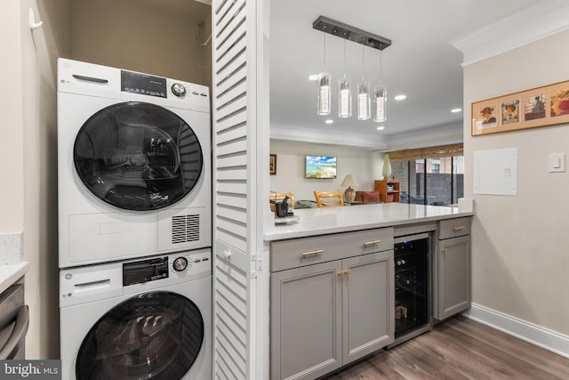 washroom with laundry area, wine cooler, dark wood-type flooring, crown molding, and stacked washing maching and dryer