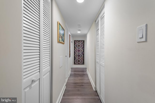 hallway with dark wood-style floors and baseboards