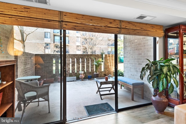 entryway featuring wood finished floors, visible vents, and floor to ceiling windows