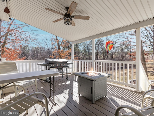 deck featuring a fire pit, ceiling fan, and grilling area