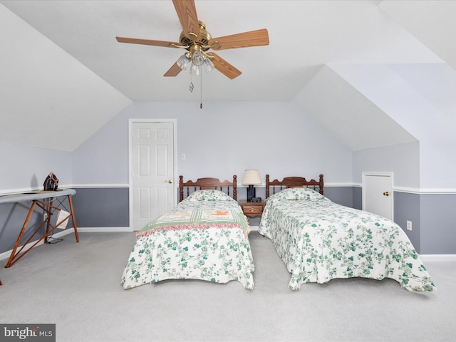 bedroom with a ceiling fan, light colored carpet, vaulted ceiling, and baseboards