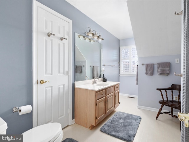 bathroom featuring toilet, vanity, and baseboards