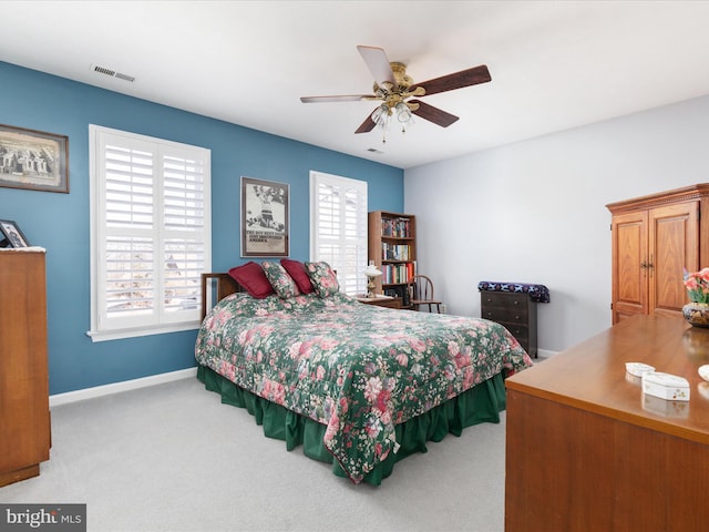 bedroom with carpet, visible vents, baseboards, and multiple windows