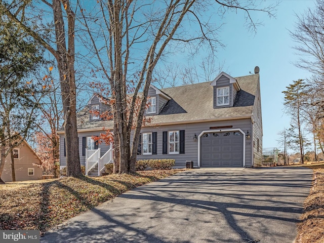 cape cod house with aphalt driveway, a shingled roof, and an attached garage