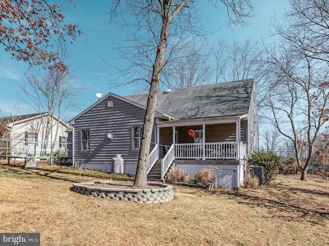 view of front of house featuring a porch, roof with shingles, and a front lawn