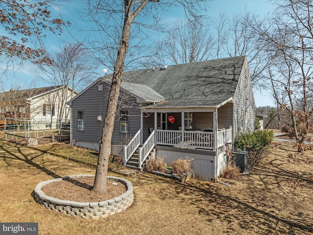 view of front of house with a porch, a front lawn, a shingled roof, and central air condition unit