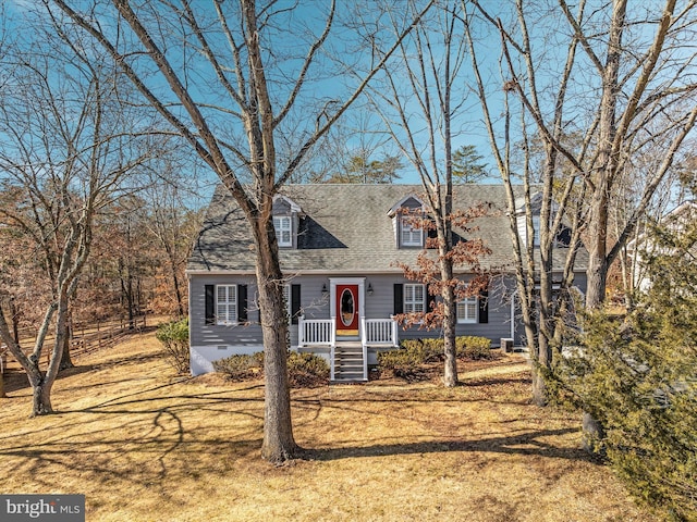 cape cod house featuring roof with shingles, a front lawn, and crawl space