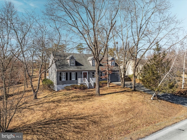 cape cod home with driveway and a front lawn