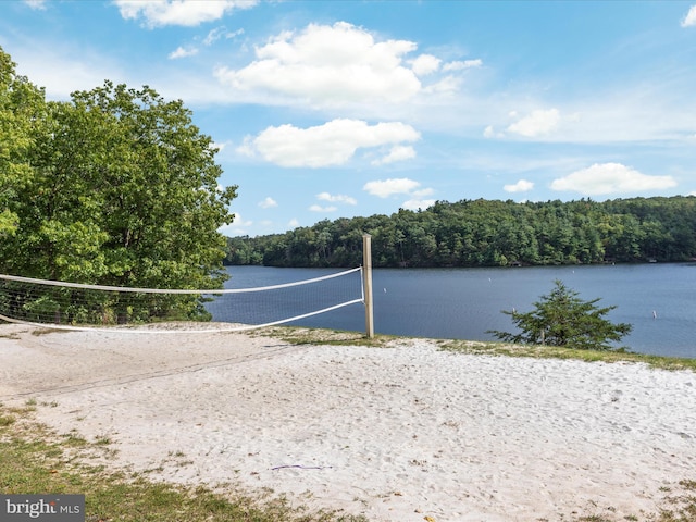 view of property's community featuring a forest view, a water view, and volleyball court