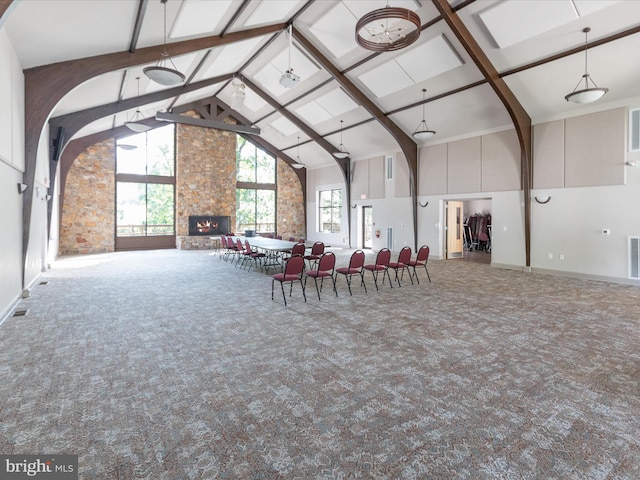 misc room featuring high vaulted ceiling, a stone fireplace, visible vents, beamed ceiling, and carpet