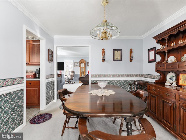 dining room with a chandelier, a wainscoted wall, light carpet, and crown molding