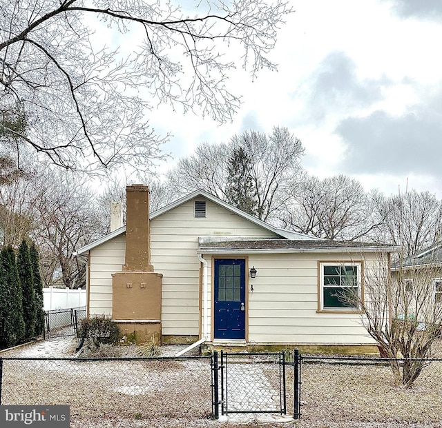 ranch-style house with a fenced front yard, a gate, and a chimney