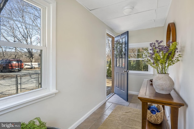 doorway featuring baseboards and light tile patterned flooring