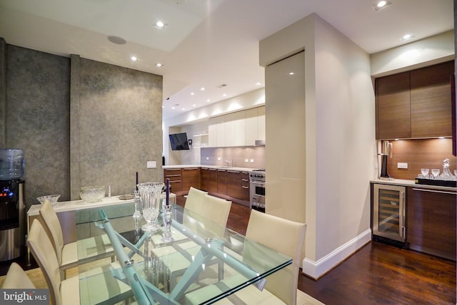 dining space featuring wood finished floors, recessed lighting, beverage cooler, and baseboards