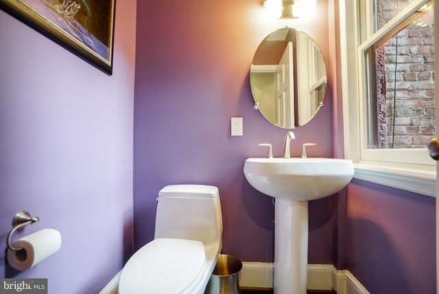 bathroom featuring baseboards and toilet