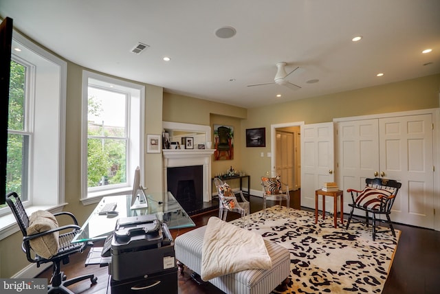 interior space featuring recessed lighting, visible vents, a fireplace with raised hearth, and wood finished floors