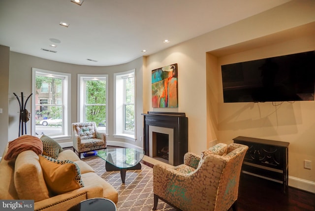 living room with visible vents, baseboards, recessed lighting, a fireplace, and wood finished floors