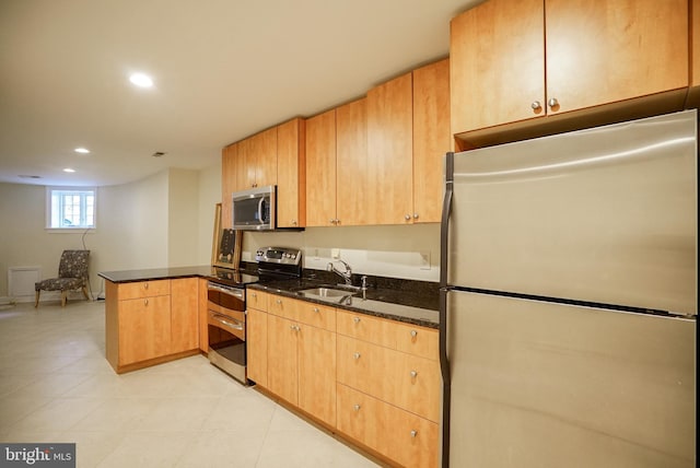 kitchen with recessed lighting, dark stone countertops, appliances with stainless steel finishes, a peninsula, and a sink