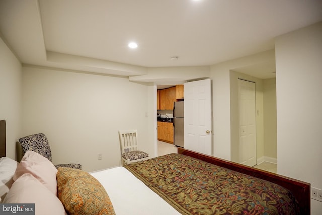 bedroom with recessed lighting, light colored carpet, and freestanding refrigerator