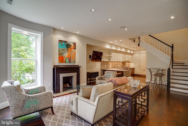 living area featuring a wealth of natural light, stairway, recessed lighting, and wood finished floors