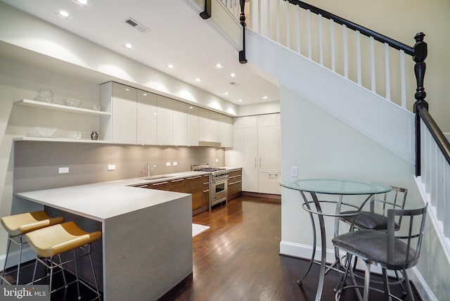 kitchen with visible vents, modern cabinets, stainless steel stove, and dark wood finished floors