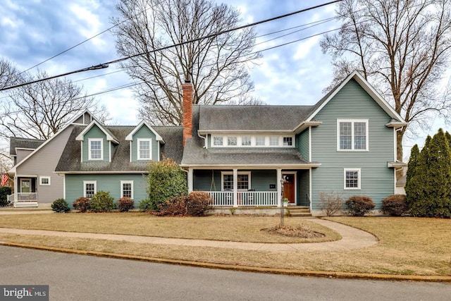 view of front of house featuring a porch, a front lawn, and a chimney