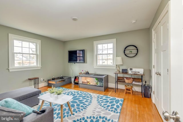 living area featuring light wood-type flooring and baseboards