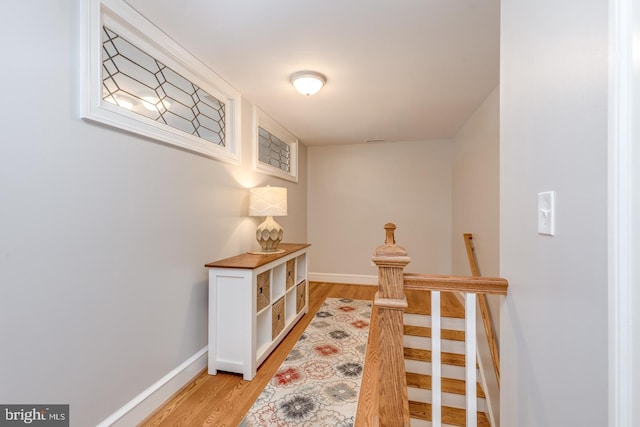 corridor with light wood-style floors and baseboards