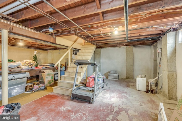 unfinished basement featuring stairway