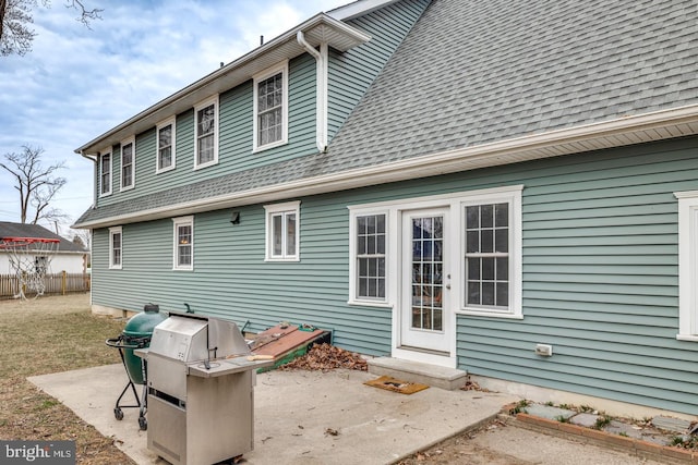 rear view of property with a shingled roof