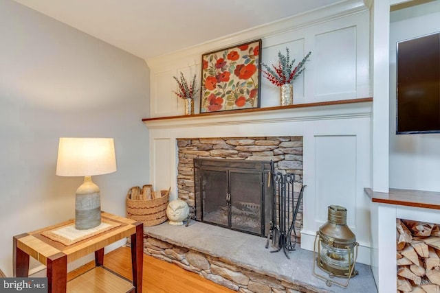 interior details with a stone fireplace and wood finished floors