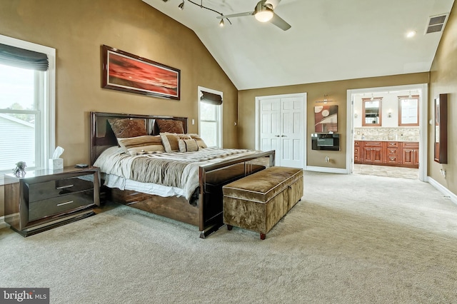 carpeted bedroom with baseboards, visible vents, connected bathroom, ceiling fan, and a closet