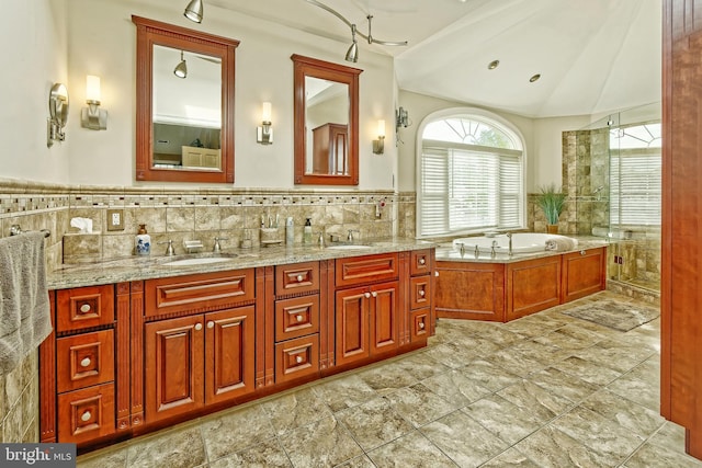 bathroom featuring double vanity, a garden tub, a sink, and lofted ceiling