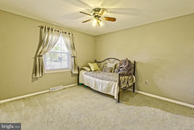 carpeted bedroom with baseboards, visible vents, and a ceiling fan