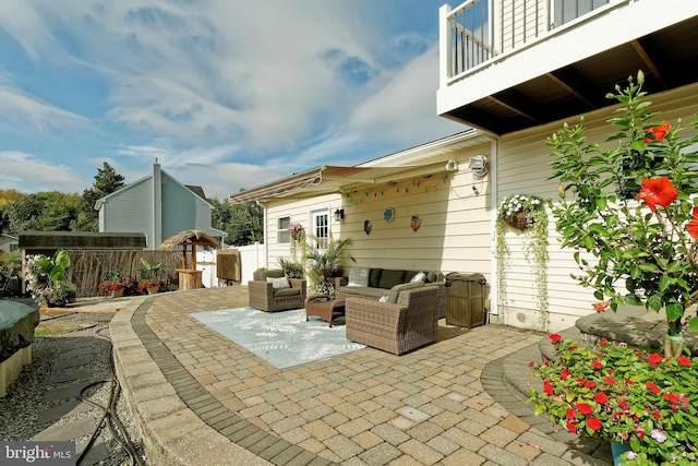 view of patio / terrace featuring fence, a balcony, and an outdoor hangout area