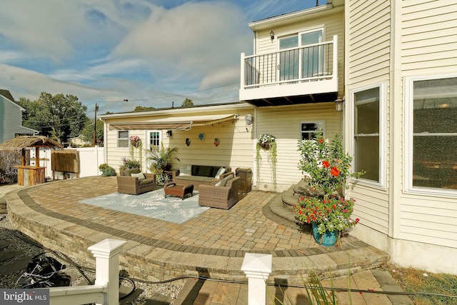 view of patio with an outdoor hangout area, fence, and a balcony