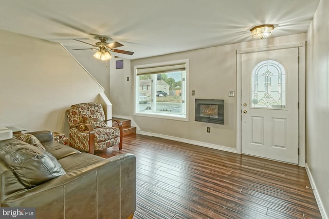 entryway featuring a ceiling fan, dark wood-style flooring, a fireplace, and baseboards