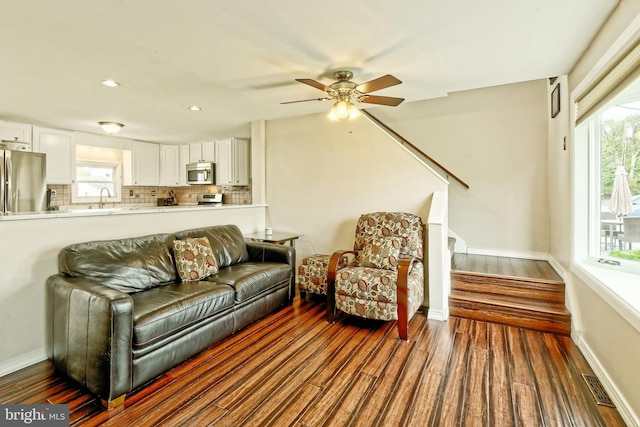 living area featuring a healthy amount of sunlight, visible vents, and dark wood finished floors