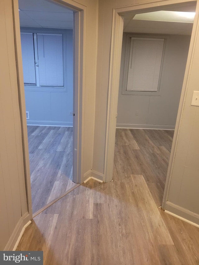 corridor with baseboards and wood finished floors